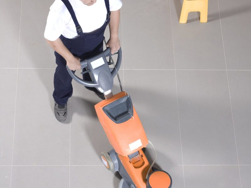 man-worker-cleaning-floor-with-scrubber-machine-image-min