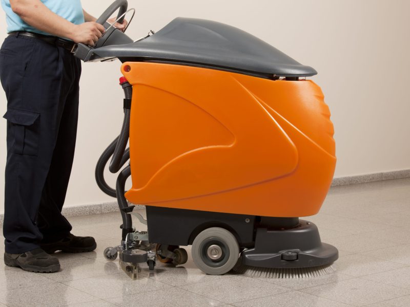 A Man worker cleaning the floor with scrubber machine. image. High quality photo